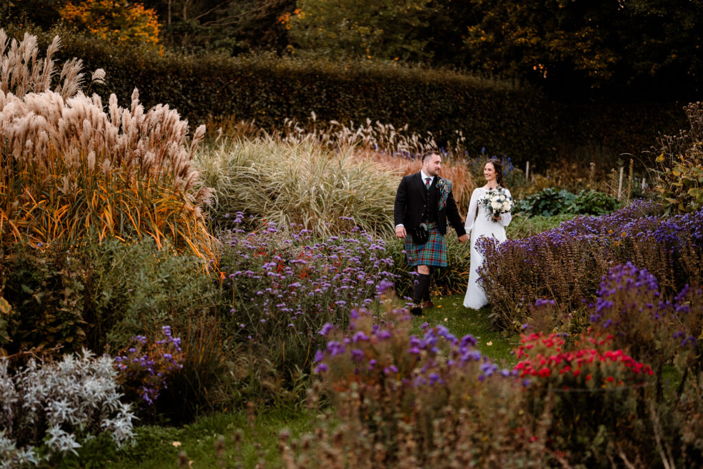 Bride and groom walking through the gardens at Nettlestead Place
